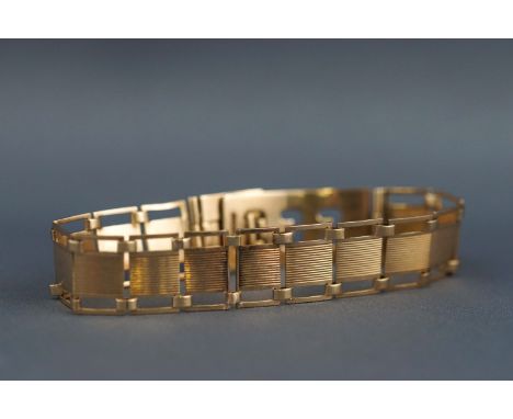A yellow metal pierced panel bracelet with adjustable clasp, stamped "9ct", 12 grams