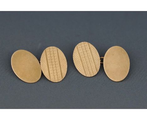 A pair of oval cufflinks, each with one end with engine turned decoration and the other plain, stamped ".375" and "9", 6.2 gr