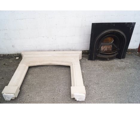 A carved sandstone mantelpiece/fire surround with cast iron grate inset, overall 125cm high x 151cm wide