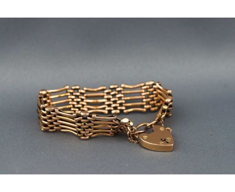 A gold five bar gate bracelet with padlock and safety chain. Stamped LW&C 9ct. 17.8 grams