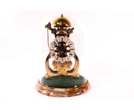 A small 20th century brass skeleton clock, engraved Thwaites and Reed, on a marble base under a glass dome, with winding key,