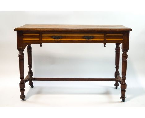A Victorian mahogany aesthetic movement side table, the single drawer frieze banded with beech on turned legs with ceramic ca