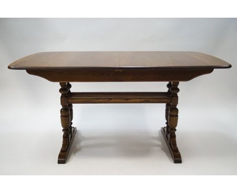 An Ercol elm draw leaf dining table with stretchered base, 74cm high x 152cm wide x 92cm deep, and six Ercol ladder back chai