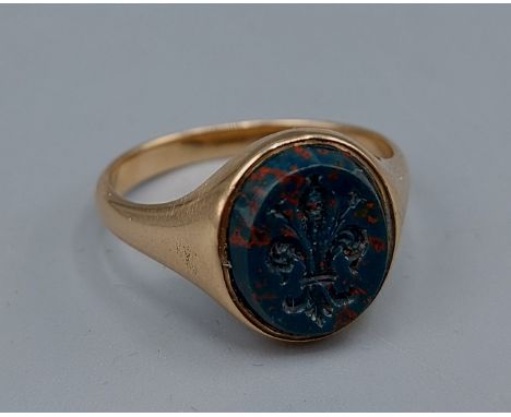 A yellow metal seal ring, the hardstone Intaglio in the form of a Fleur De Lys, 5gms, ring size M