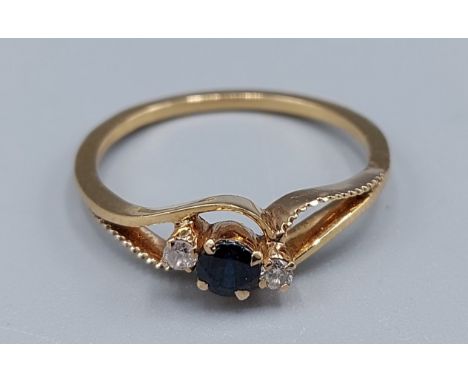 An 18ct gold Sapphire and Diamond ring set with a Sapphire flanked by Diamonds within a pierced setting, 2.4gms, ring size P