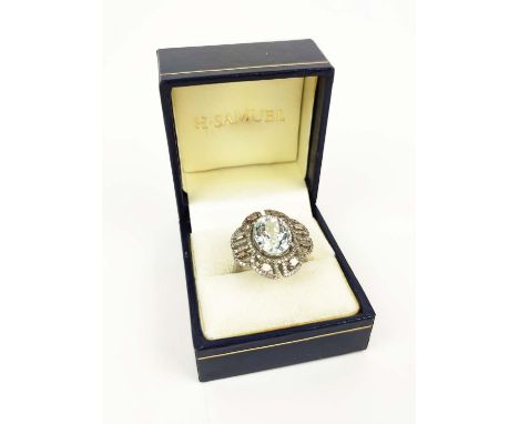 AN AQAUAMARINE AND DIAMOND ENCRUSTED DRESS RING, the large claw set oval mixed cut aquamarine of approximately 7.60 carats, s