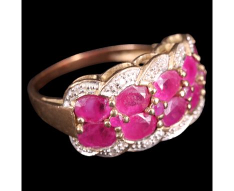 A diamond and ruby dress ring, comprising rows of round and oval cut rubies pavé-set within a diamond-set guilloche border, b