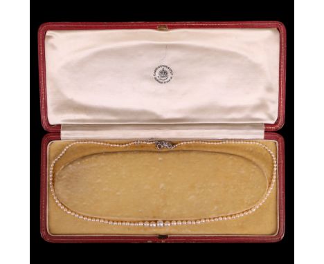 An antique graded single-strand pearl necklace having a diamond-set flowerhead gold box clasp, in Carrington &amp; Co case, l