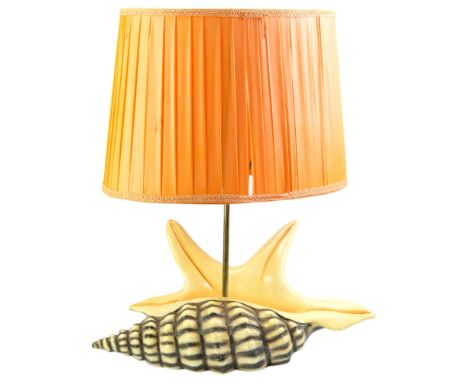 A mid 20th Century spider conch shell table lamp, having a pleated orange shade and plaster body, 941443, 32 cm to top of soc