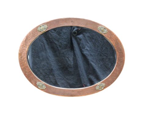 A vintage copper-and-brass-framed wall mirror with floral embellishments, having an oval bevel-edged plate, 53 cm x 71 cm ove