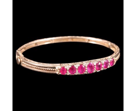 A ruby, diamond and 9 ct gold hingled bangle, comprising seven graded oval-cut rubies of approx 2.5 ct aggregate weight divid