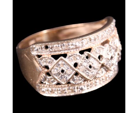 A contemporary diamond and 9 ct gold finger ring, its broad pierced decorative face millegrain-set with small diamond brillia