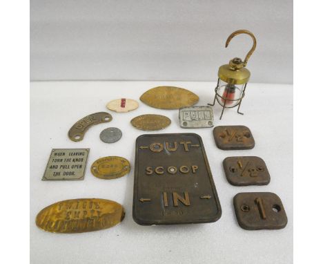 A collection of brass goods wagon tags, cast metal numbered plates and a small brass hanging lantern.