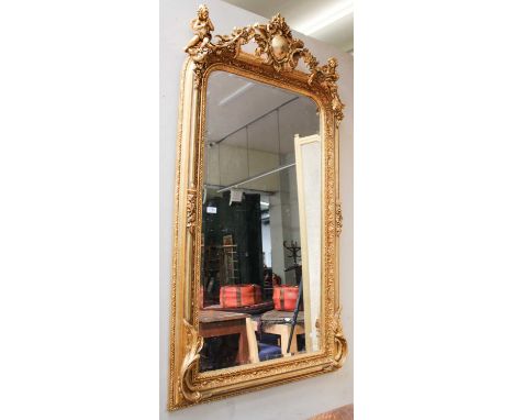 A 20th century Gilt Framed Mirror, with bevelled plate and floral swags, surmounted by cherubs, 85cm by 165cm