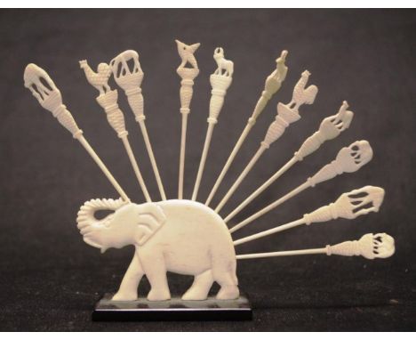 Carved ivory elephant figure with toothpicks carved elephant on ebony stand, with 11 carved ivory toothpicks, (height 5cm app