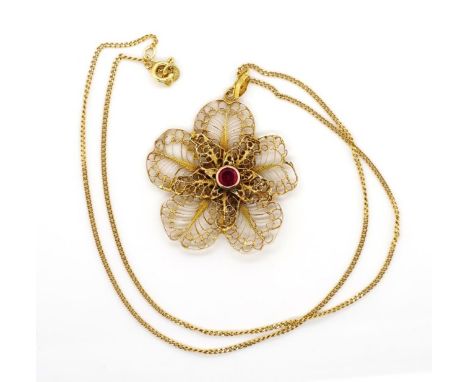 18ct yellow gold pendant and Cuban link chain with a filigree flower pendant bezel set with a solitaire red gemstone tests as