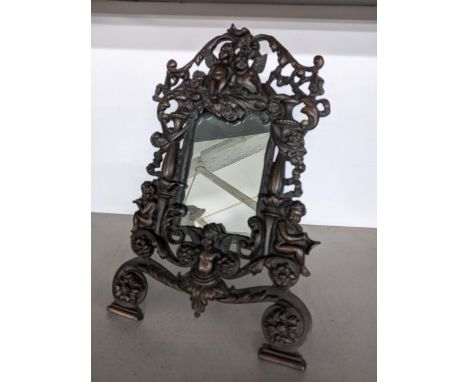 A small late 19th/early 20th century cast iron mirror with easel back, decorated with cherubs and classical design 