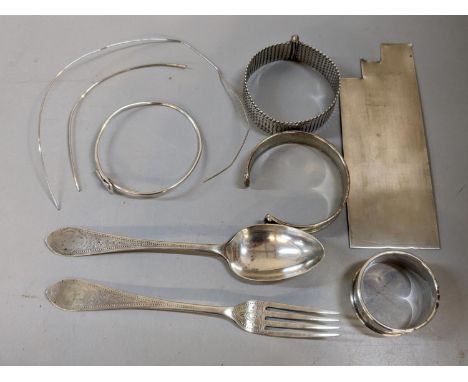 A collection of silver and white metal to include a silver christening fork, spoon and napkin 