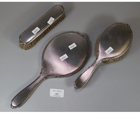 Three piece silver engine turned ladies vanity set comprising: hand mirror and two brushes.  (B.P. 21% + VAT) 