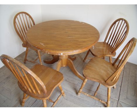 Modern light oak style circular dining table and four hoop backed dining chairs with solid seats 