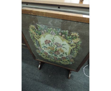 An early 20th Century stained frame fire screen having embroidered inset