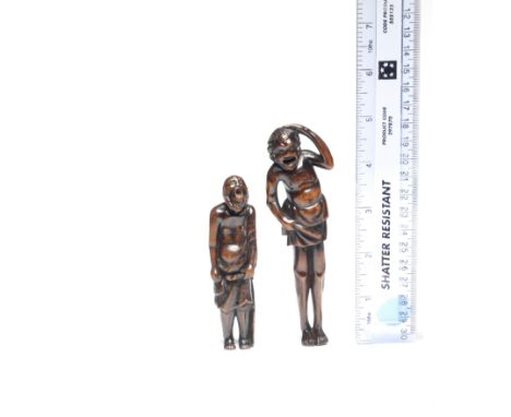 TWO TALL WOOD NETSUKEEdo period (1615-1868), late 18th to mid-19th centuryThe first a long-legged South Sea Islander standing