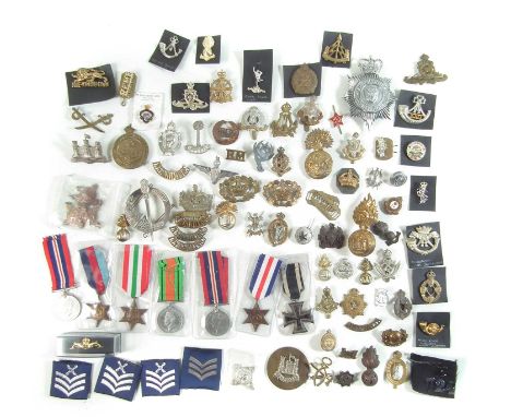 Approximately seventy five Cap badges, mainly British Army, also a WWI German Iron Cross and a set of WWII medals.
