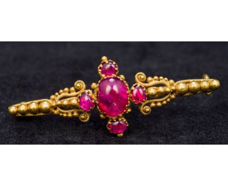 A Victorian unmarked gold and ruby bar broochCentrally set with five cabochon rubies.  4 cm long.    CONDITION REPORTS:  Some