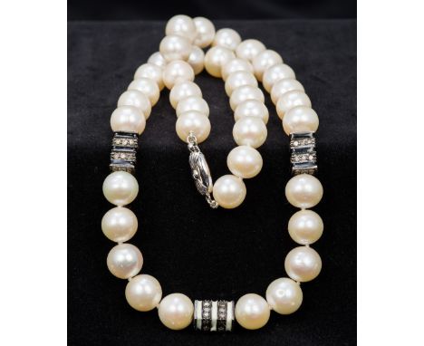 A pearl necklaceThe pearls interspersed with three enamel and diamond set spacers.  46 cm long.   CONDITION REPORTS:  General