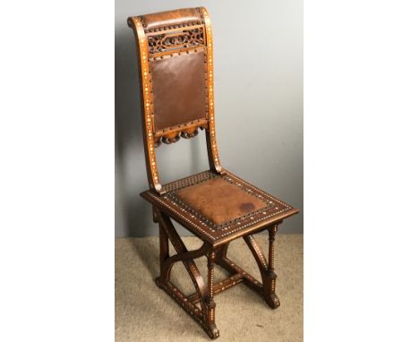 A 19th century North African bone inlaid side chairThe pierced carved leather upholstered back above the studded leather upho