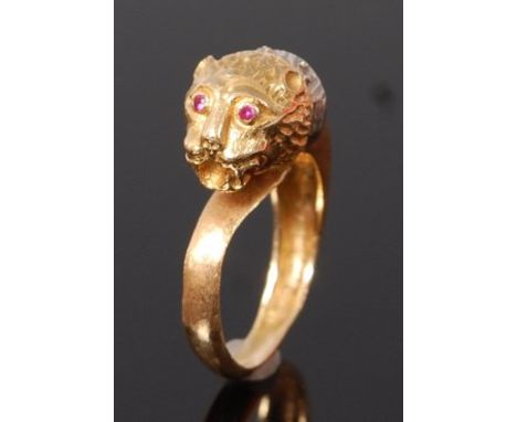 A modern 18ct gold, sapphire and ruby set dress ring, modelled as a lion mask, with ruby set eyes and white sapphire point se