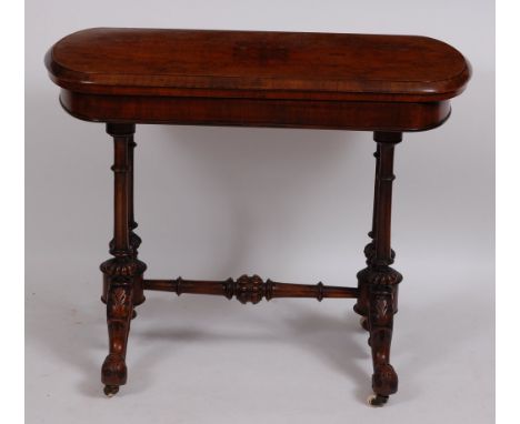 A Victorian walnut card table, the rectangular fold-over top revealing baize lined playing surface, on turned and fluted end 