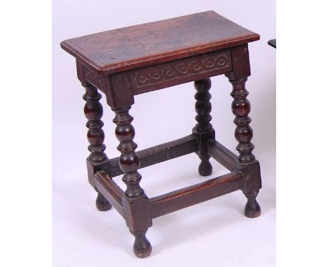 *A circa 1700 oak joint stool, the top having a moulded edge and carved frieze, on bobbin turned supports united by low squar