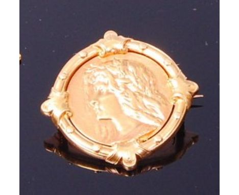 An Art Nouveau period yellow metal brooch, as a profile portrait of a girl within fixed circular mount, unmarked but tests as