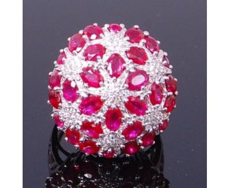 An 18ct white gold, ruby and diamond cocktail ring, the large convex setting diameter 26mm, pavé set with oval cut rubies dis