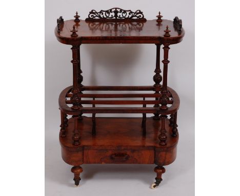 A Victorian figured walnut canterbury whatnot, having fret carved three-quarter gallery on turned and fluted supports with si