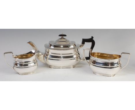 A George V silver three-piece tea set in the Regency style, comprising teapot , twin handled sugar and cream, each of oval bo