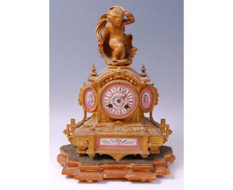 A 19th century French gilt metal and porcelain inset mantel clock, the whole surmounted with a cherub above a Sèvres style po