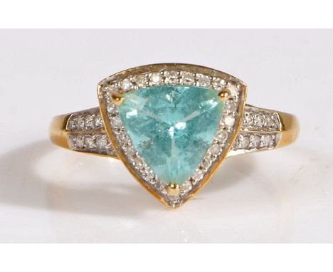 A 18 carat gold paraiba tourmaline and diamond ring, the head set with a claw mounted triangular cut paraiba tourmaline stone