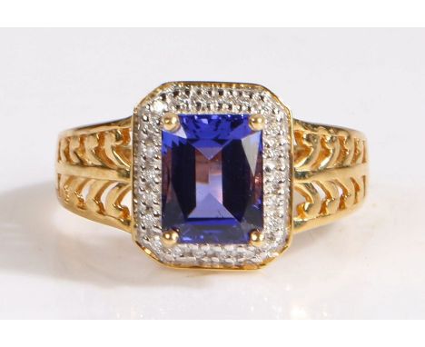 A 18 carat gold AAA tanzanite and diamond ring, the head set with a claw mounted antique cut AAA tanzanite stone surrounded b