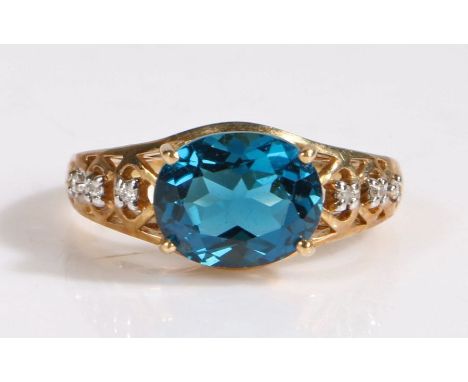 A 9 carat gold London blue topaz and diamond ring, the head set with a claw mounted oval cut London blue topaz together with 