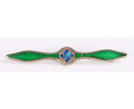 A silver and enamel bar brooch in the form of propeller, set with a swastika to the center in blue enamel and green enamel to