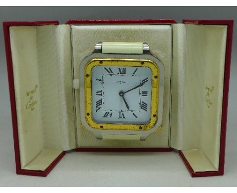 A Cartier quartz travelling alarm clock in a tooled case, bezel a/f
