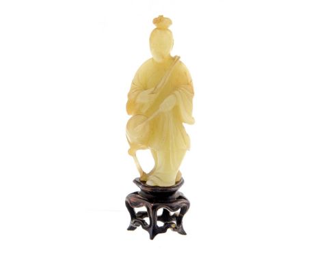 A Chinese pale jade figure, 18th/19th Century, carved as a standing robed figure beating a drum, height 8cm, on a wooden stan