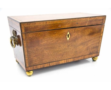 A Regency mahogany and crossbanded tea caddy, circa 1825, of sarcophagus form, brass ring handles, fitted interior with a cen