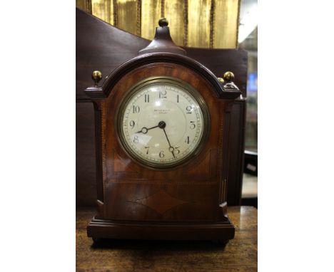 An Edwardian Maple & Co mahogany bracket clock, barbers pole strung, caddy top with ball finials, enamel dial flanked by flut