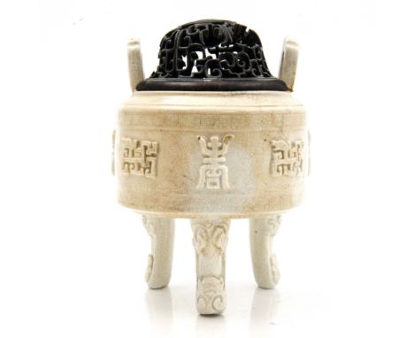 A Blanc de Chine, whiteware tripod censer, with a frieze of archaistic characters in relief, with reticulated hardwood lid, 1