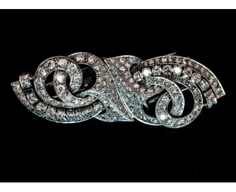 An Art Deco diamond double clip mounted on bar brooch of stylised scroll openwork form, set numerous graduated brilliant cut 
