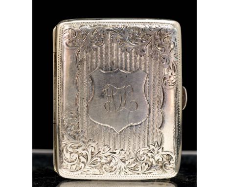 An Edwardian silver cigarette case, the cover and base engraved with foliate decoration and striation patterns, the cover wit