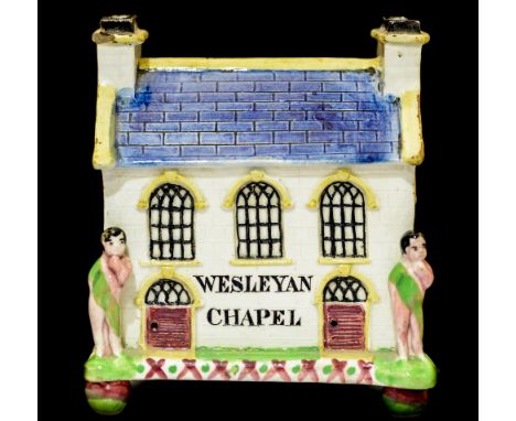 A Staffordshire Prattware Wesleyan Chapel moneybox, realistically modelled with chimneys and putti, Christies label underside